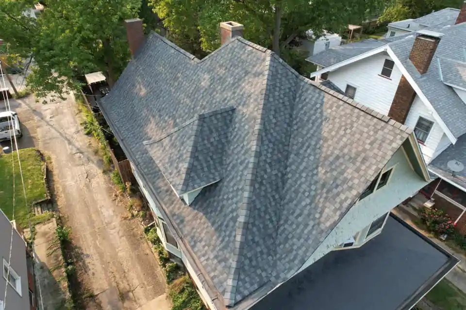 A damaged roof section with several shingles torn away by high winds, illustrating a typical scenario for storm damage.