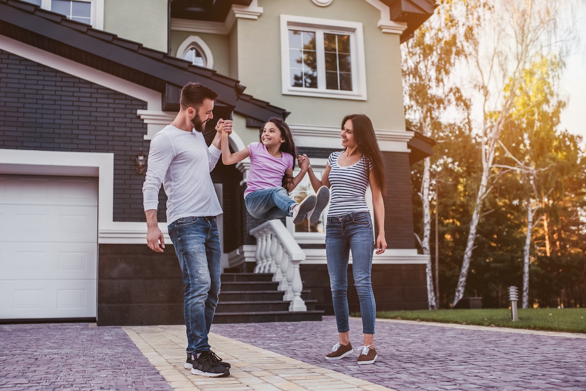 Happy family is having fun outdoors near their private house.