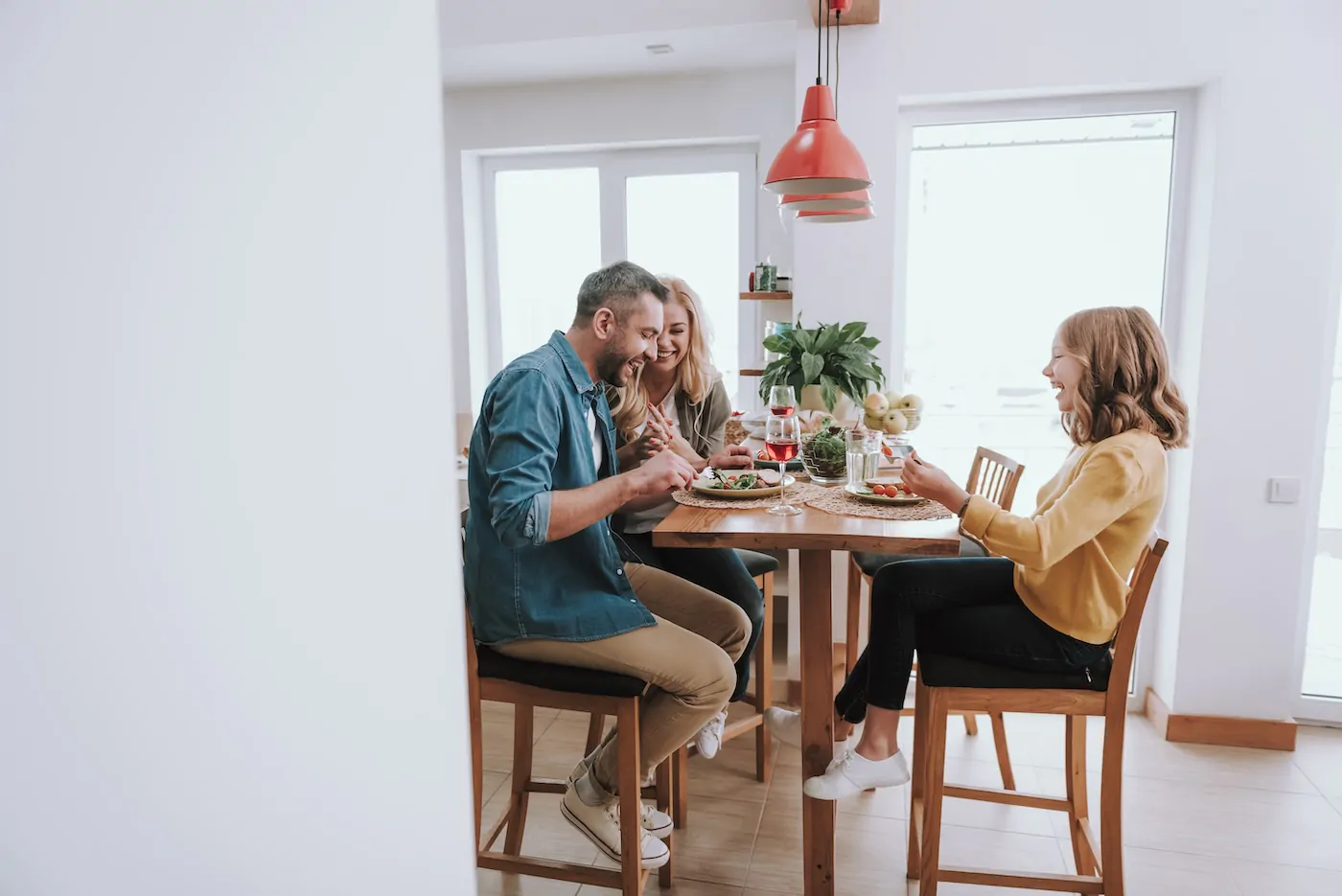 Happy family having dinner, chatting and laughing at home