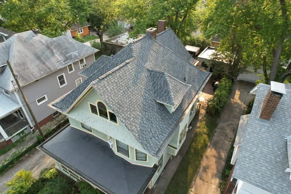 Close-up aerial view of grey ridge cap shingles providing a professional finish on a multi-gabled residential roof.