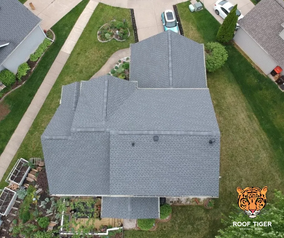 Vertical drone view of a clean grey shingle roof featuring several black roof vents for proper attic ventilation, completed by ROOF TIGER.