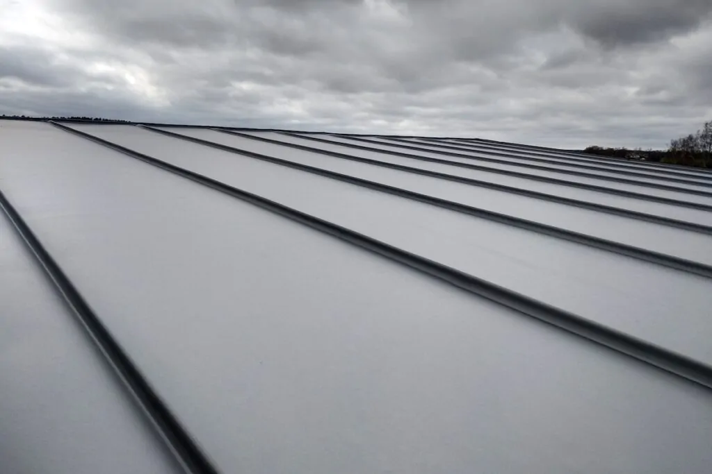 Close-up detail of house roof made from gray metal sheets.