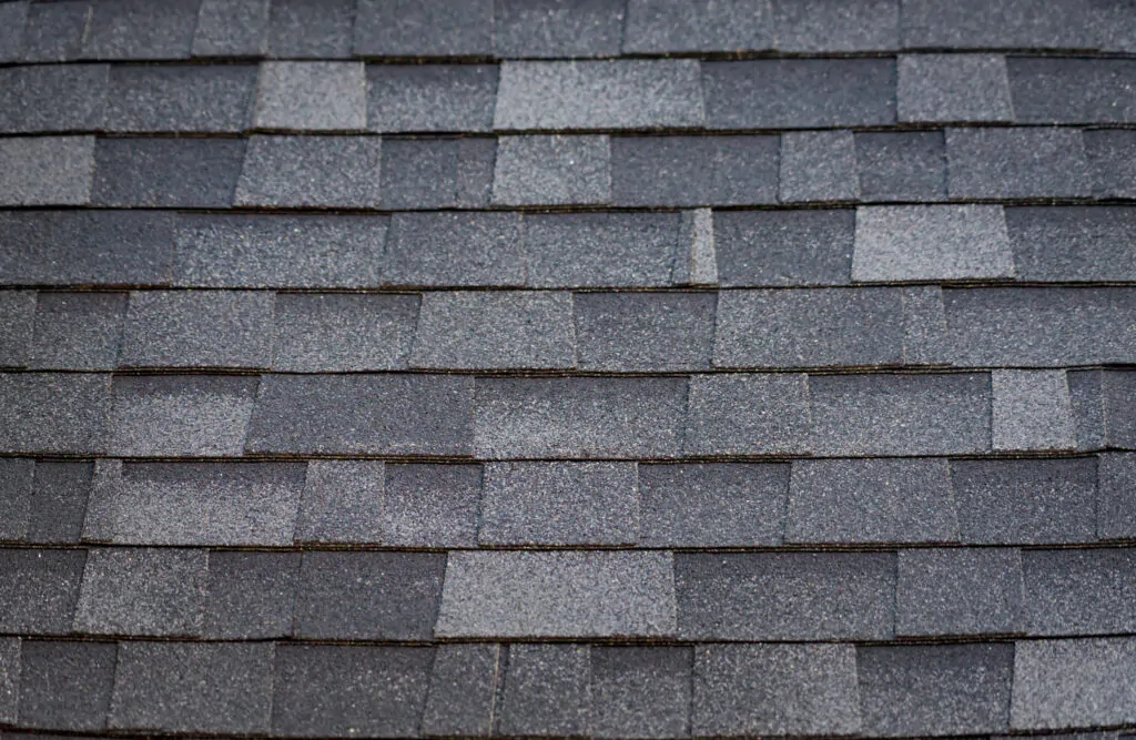 A close-up comparison of architectural shingles vs 3 tab shingles, highlighting the multi-dimensional, layered texture of the architectural style installed by The Roof Tiger.