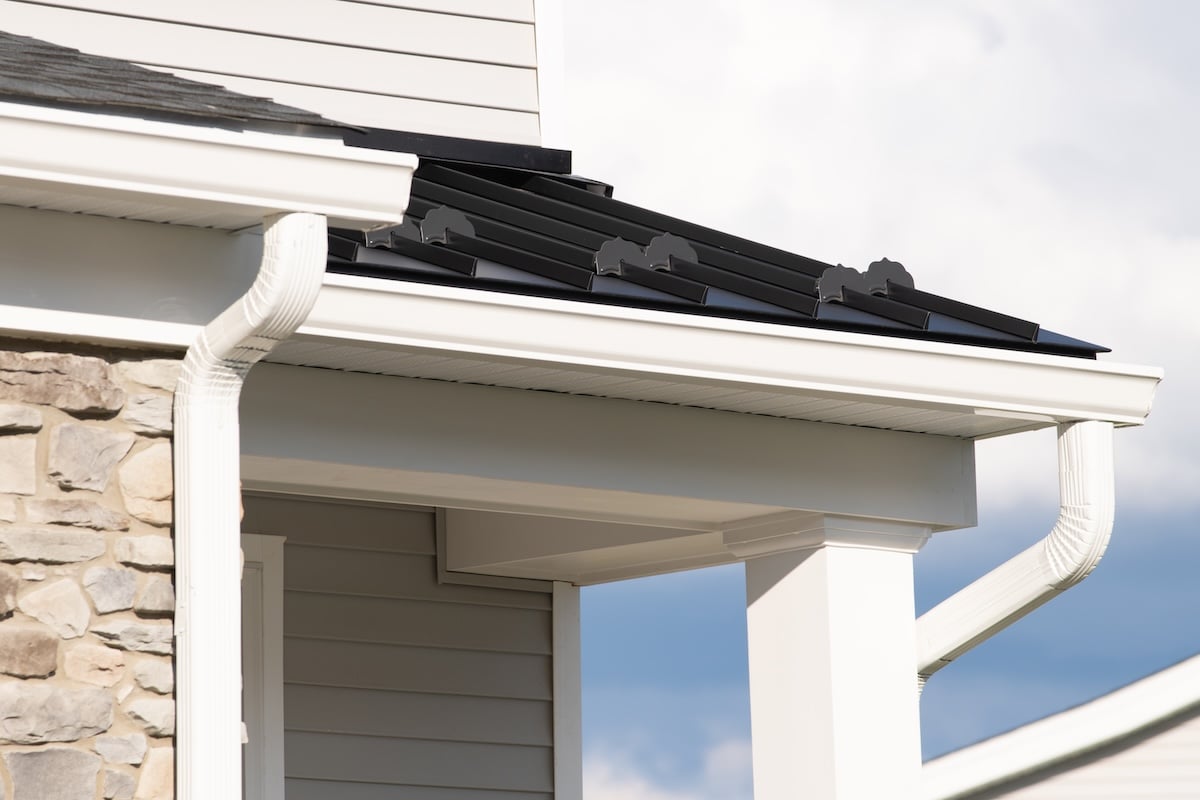 New rain gutter on a home against blue sky rain facade white