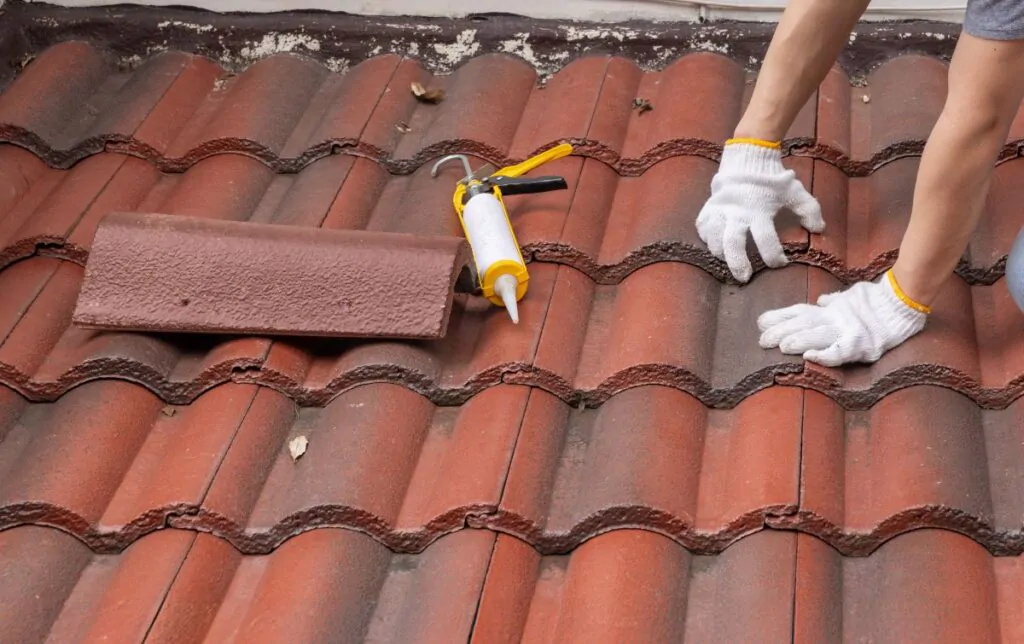 Construction worker is inspecting roof tile cracked.